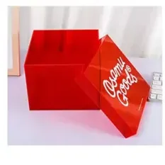 A red cast acrylic box carrying a solid white script printed across its lid