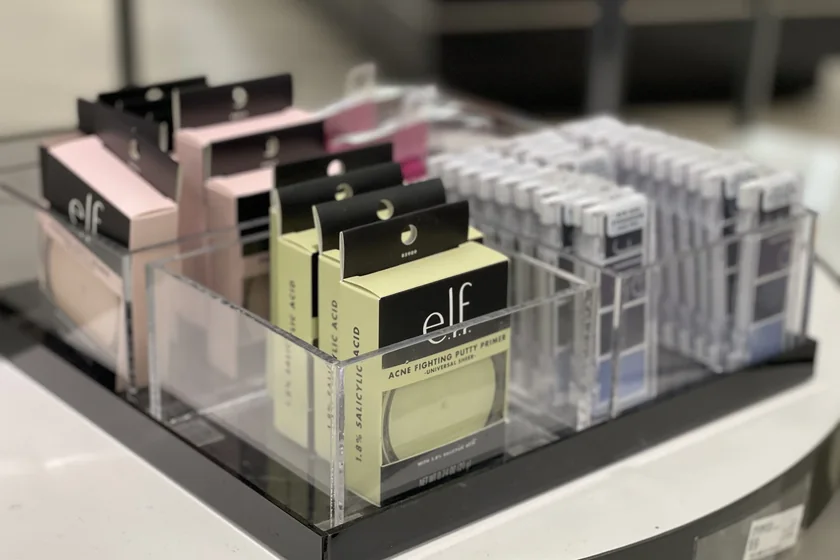 Clear acrylic organizers holding cosmetics and boxed beauty products on a display table
