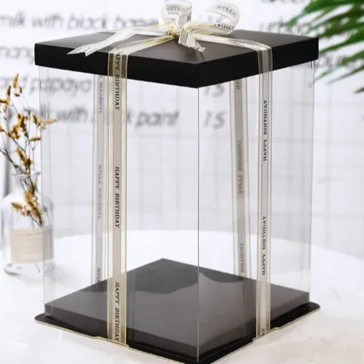 A clear acrylic display box with a slim black base and a printed ribbon, standing on a pale table