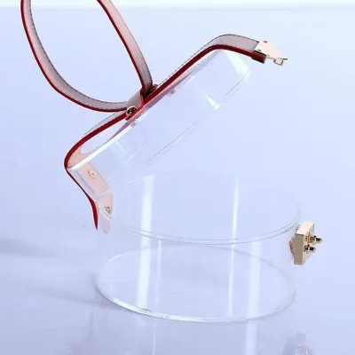 A clear acrylic box closed by a small metal clasp, photographed against a pale blue sweep