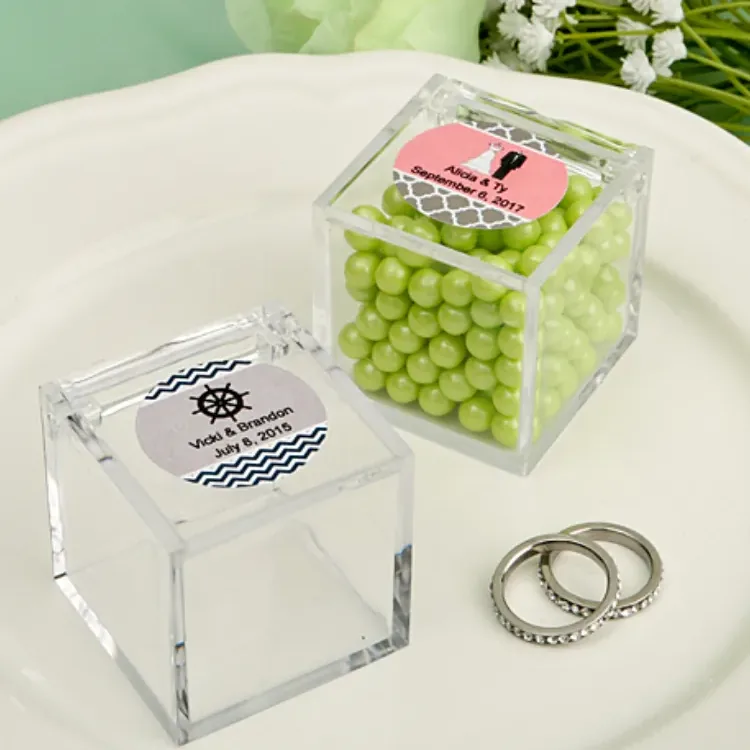 Two small clear acrylic cubes, each carrying a printed round insert under its lid, on a white plate