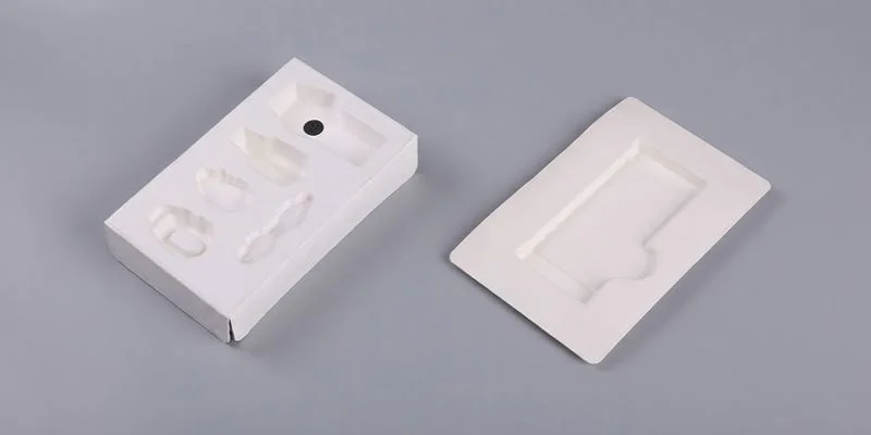 Two white molded paper pulp trays with formed cavities for pod cartridges