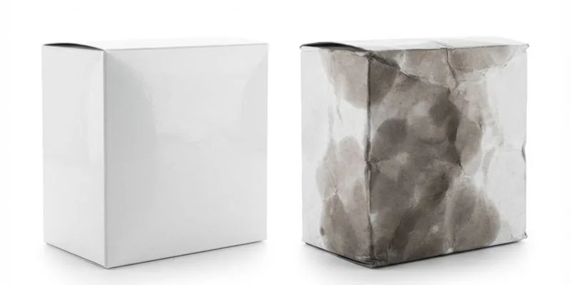 An unmarked white box beside an identical box discolored by oil stains