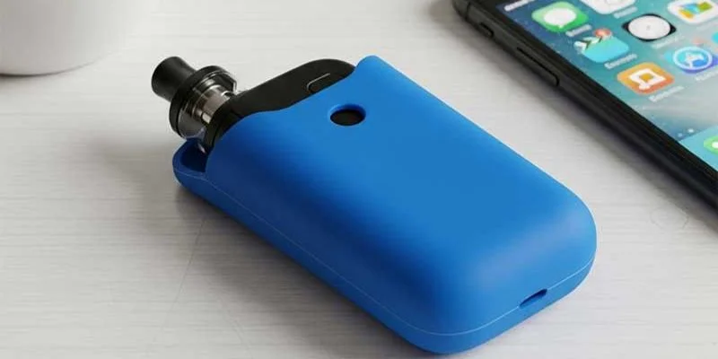 A blue silicone case holding a vape mod on a wooden desk