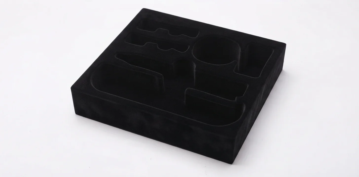 A black velvet-flocked EVA insert with die-cut pod cavities