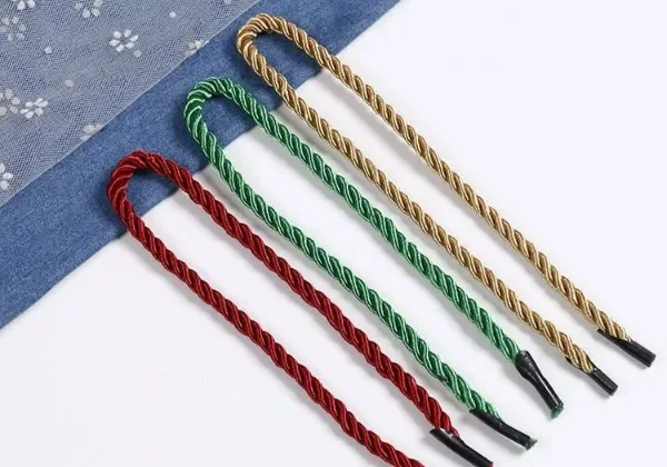 A satin-finish flat nylon cord handle with a reinforced anchor on a kraft bag