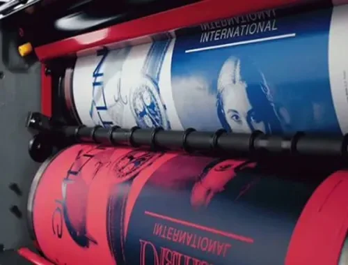 A sheet-fed offset printing press running a large printed sheet