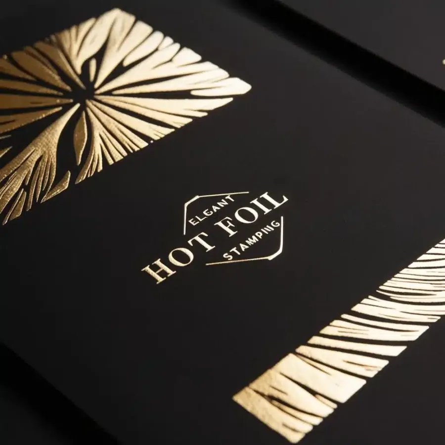 A gold foil logo stamped on a black carton