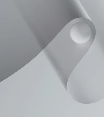 A roll of clear barrier film curving through a pale minimal frame