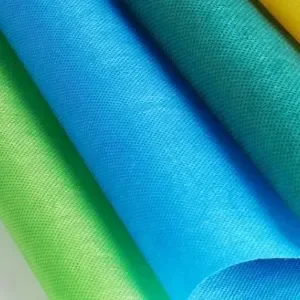 Bolts of lime green and blue nonwoven polypropylene fabric, close up