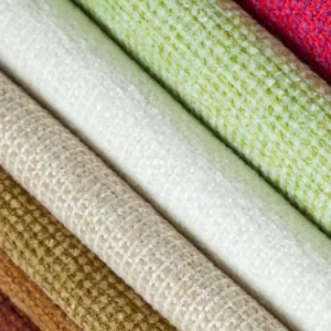 Rolled bolts of organic cotton jersey in cream, sage and natural brown