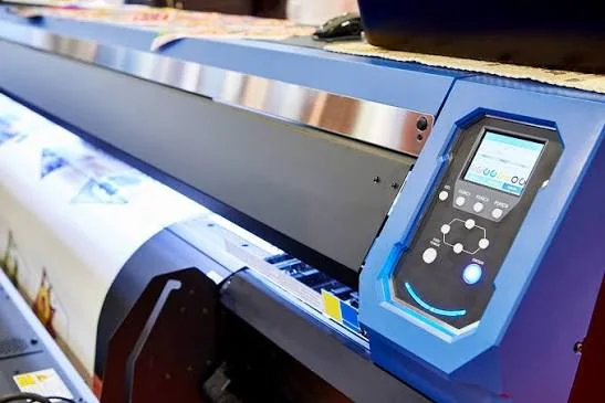 A wide-format roll printer running printed polyester fabric under the print head