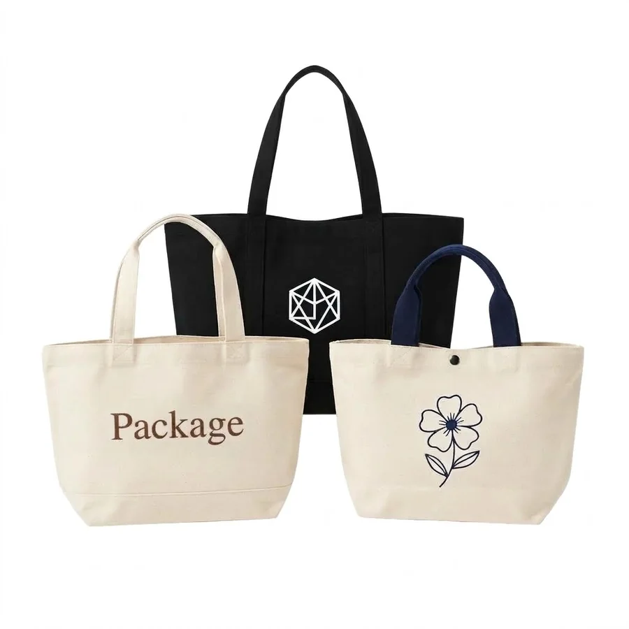 A black, a cream and a navy-handled cotton canvas tote, one printed with a line-drawn flower