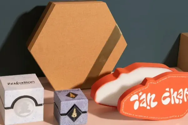 Hexagonal and curved rigid boxes in kraft, cream and orange