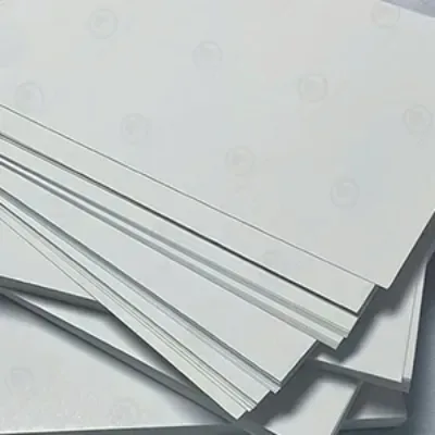 A stack of grey recycled chipboard sheets fanned on a pale surface