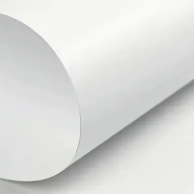 A roll of coated bleached white carton board on a grey background